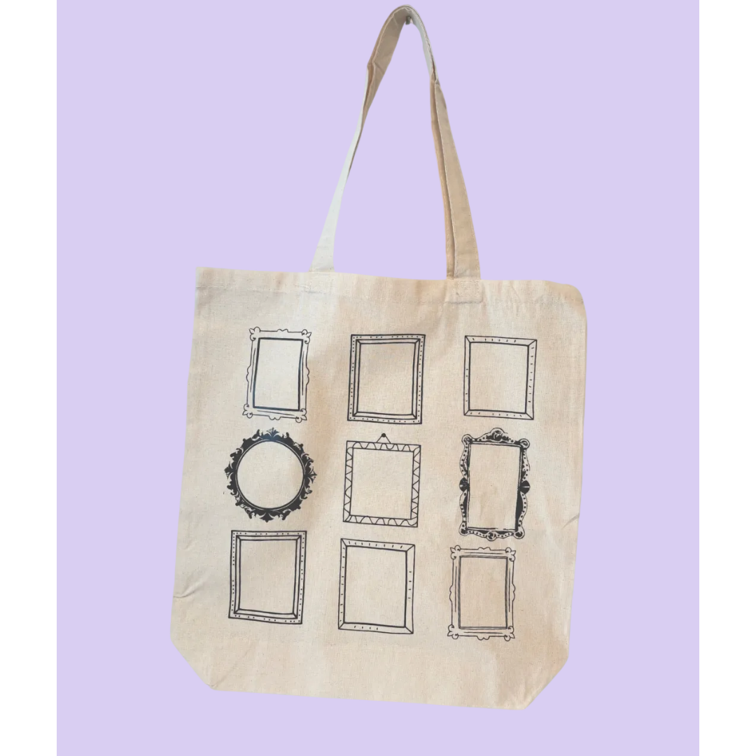 A natural canvas tote bag with nine black-framed picture frame prints on the front, set against a solid light purple background.